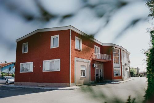 un edificio de ladrillo rojo con balcón en una calle en Guest House Sv. Nikola, en Dugo Selo