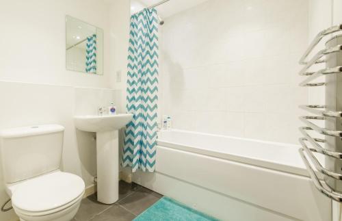 a white bathroom with a toilet and a sink at Apartment D204 in Northampton