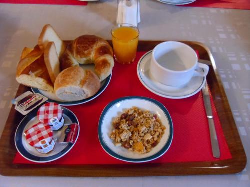 - un plateau de nourriture avec du pain et une tasse de jus d'orange dans l'établissement Hôtel De Bale, à Mulhouse