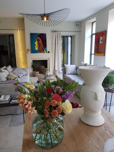 a living room with a vase of flowers on a table at La Magnanerie de l'Isle B&B in LʼIsle-sur-la-Sorgue