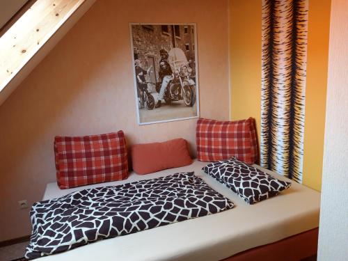 a room with a bed and two pillows at Wildholz Sachsen in Weidenhain