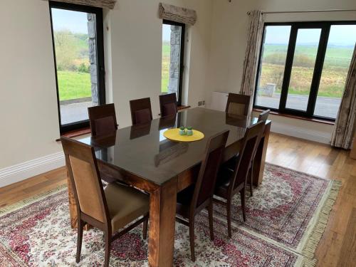uma sala de jantar com mesa e cadeiras em Burrowlodge em Kilfenora