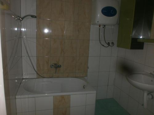 a bathroom with a bath tub and a sink at APARTMANI LAŠTRO in Jesenice