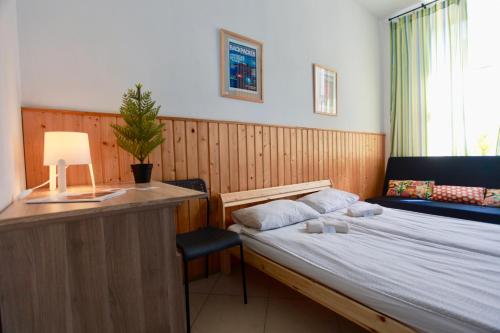 a bedroom with a bed and a desk with a plant at BedandBike Rooms in Saint Petersburg