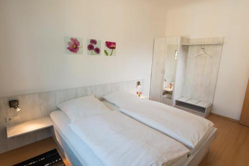 a bedroom with a large white bed and a mirror at City Hotel in Eisenach