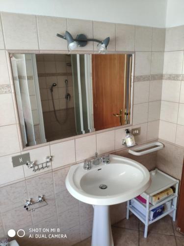 a bathroom with a sink and a mirror at Old style flat in Nebida