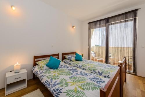 a bedroom with two beds and a large window at Apartment- SUNCE in Kaštela