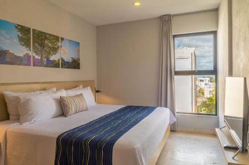 a bedroom with a large bed and a window at Hotelito del Mar Playa del Carmen in Playa del Carmen
