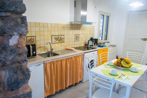 a kitchen with a sink and a table with bananas on it at La Zagara in Aci Castello