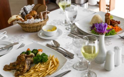 a white table with plates of food and glasses of wine at Tangerine Beach Hotel in Kalutara