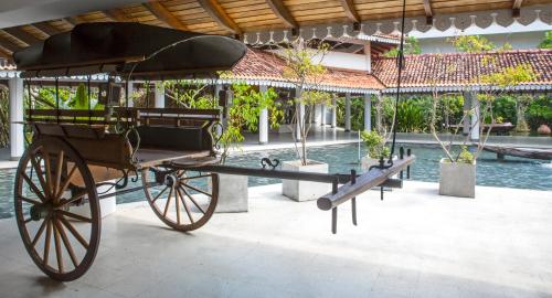 a horse drawn carriage next to a swimming pool at Tangerine Beach Hotel in Kalutara