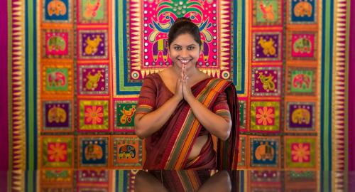 a woman is sitting in front of a colorful wall at Tangerine Beach Hotel in Kalutara