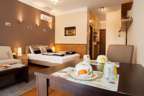 un soggiorno con letto e tavolo con piatti di Katrin Apartment a Budapest