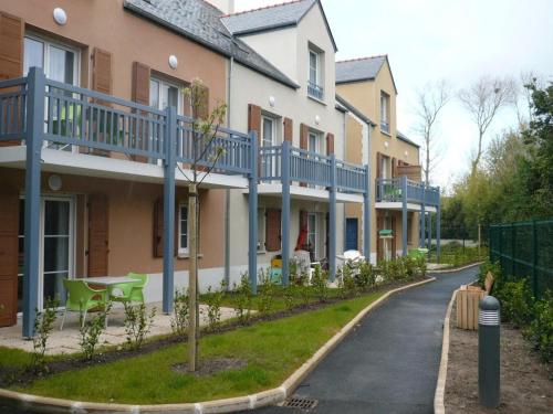 a row of houses with blue balconies on a street at Guilvinec Parc Residence in Le Guilvinec