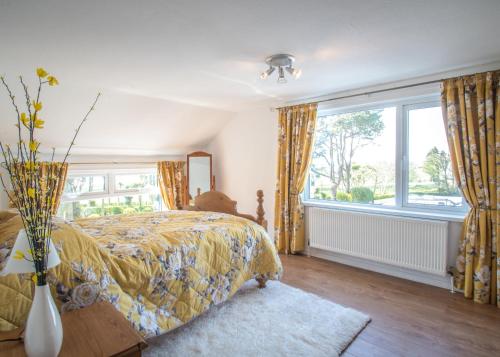 a bedroom with a bed and a large window at Mallard Cottage in Whitehead