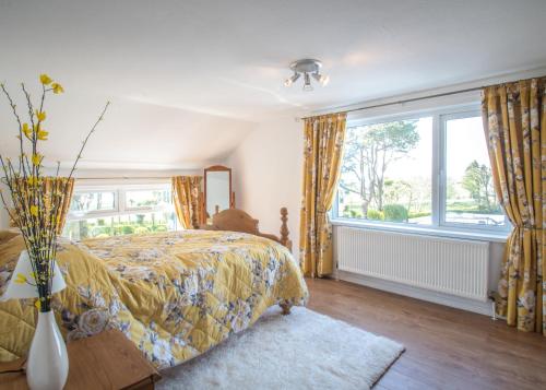 una camera da letto con un letto e una grande finestra di Mallard Cottage a Whitehead