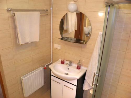 a small bathroom with a sink and a mirror at APARTAMENT BERMUDY in Świnoujście