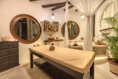 a bathroom with a table and a tub and mirrors at Beachfront Hotel La Palapa - Adults Only in Holbox Island