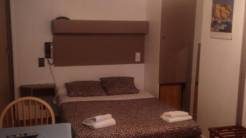 a small bedroom with a bed with towels on it at Hotel de Savoie in Annecy