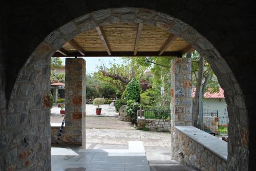 a stone archway with a bench in a courtyard at Petras Gi - Stone Houses in Stoupa