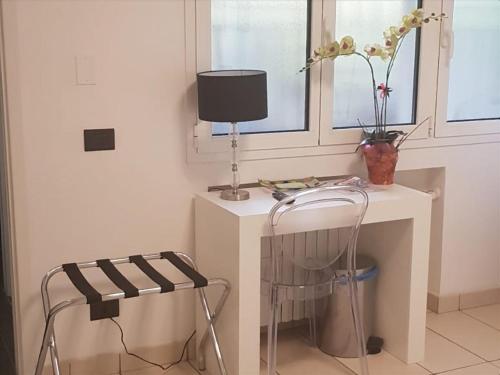 una scrivania bianca con lampada e sedia di Tamb&B2 a Bologna