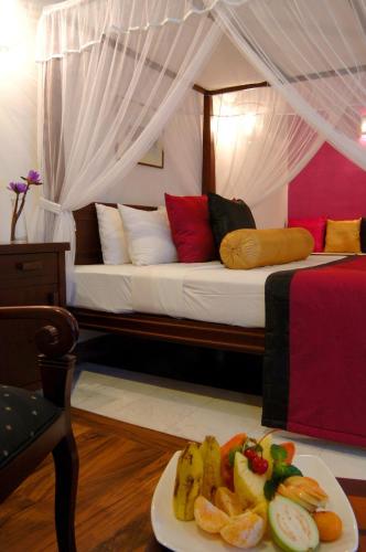 a bedroom with a bed with a plate of food at Tangerine Beach Hotel in Kalutara