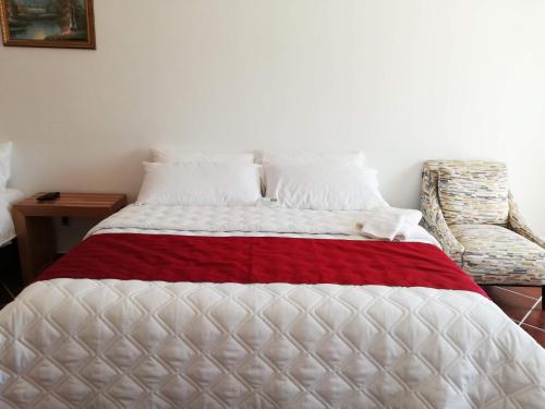 a bedroom with a bed with a red and white blanket at Hacienda Maxdá in Santiaguito Maxdá