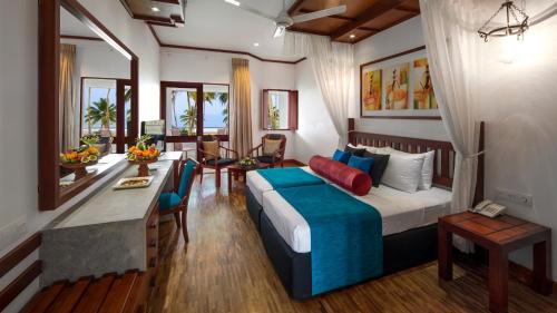 une chambre d'hôtel avec un lit et une salle à manger dans l'établissement Tangerine Beach Hotel, à Kalutara