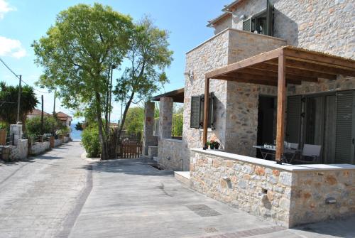 a stone house with a porch on a street at Petras Gi - Stone Houses in Stoupa