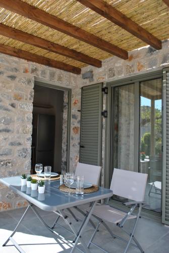 a table and two chairs on a patio at Petras Gi - Stone Houses in Stoupa