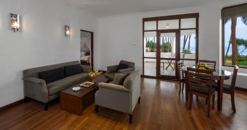 a living room with two couches and a table at Tangerine Beach Hotel in Kalutara
