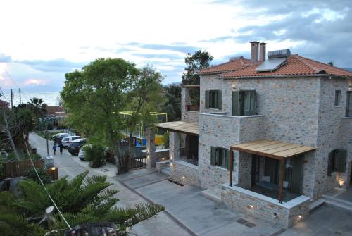 a house on a street with cars parked at Petras Gi - Stone Houses in Stoupa