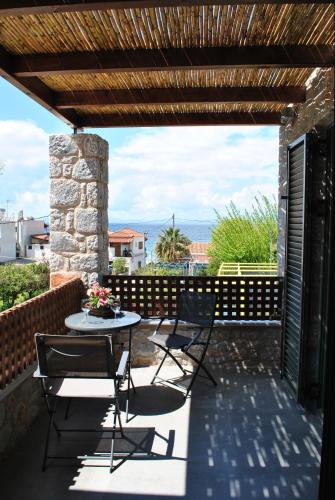 a patio with chairs and a table on a patio at Petras Gi - Stone Houses in Stoupa