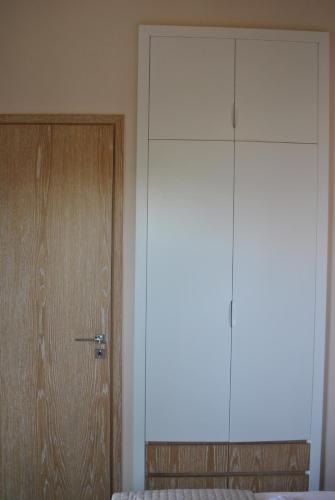 a room with a door and a bed and a closet at Petras Gi - Stone Houses in Stoupa