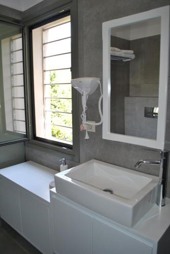 a bathroom with a white sink and a mirror at Petras Gi - Stone Houses in Stoupa