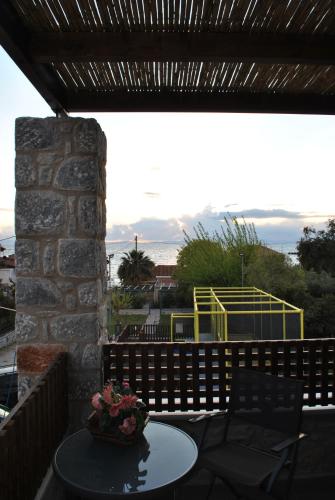 a table and chairs on a patio with a view at Petras Gi - Stone Houses in Stoupa