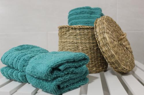 two towels and a basket on a table at BaixaMar Apartments in Olhão