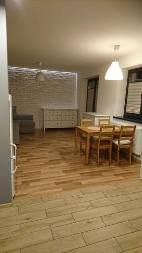 sala de estar con mesa de madera y sillas en Nowy apartament Bydgoszcz centrum, en Bydgoszcz