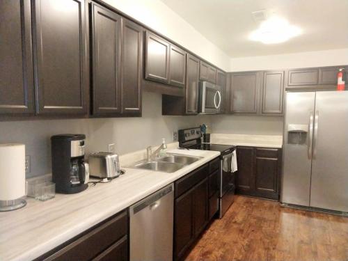 a kitchen with wooden cabinets and a stainless steel refrigerator at Inviting Condo in Central Raleigh in Raleigh