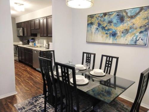 a dining room with a table and chairs and a kitchen at Desirable Condo in Central Raleigh in Raleigh