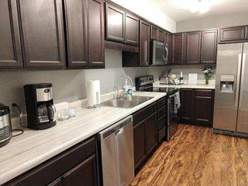 a kitchen with wooden cabinets and stainless steel appliances at Awesome Condo in Central Raleigh in Raleigh