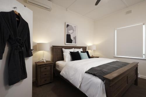 a bedroom with a large bed and a window at Tomfoolery Winemaker's Cottage Barossa Valley in Lights Pass