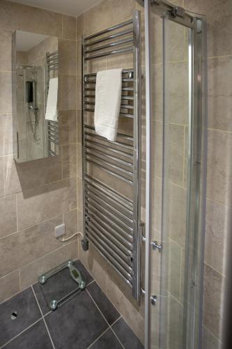 a shower with a glass door in a bathroom at Sea Road Apartments in Bournemouth