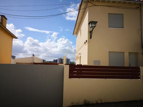a building with a fence and a blue sky at Be My Neighbour in Lisbon