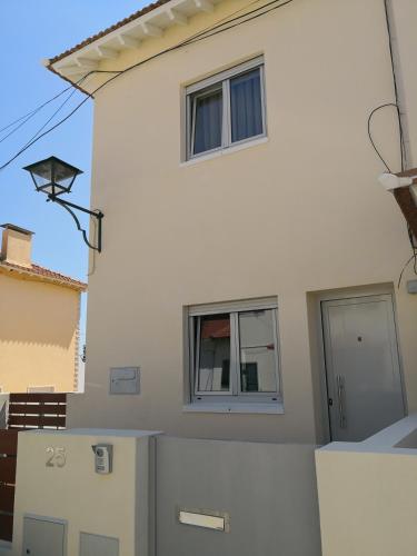 a white house with two windows on the side of it at Be My Neighbour in Lisbon