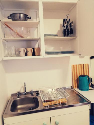 a kitchen sink with a dish rack next to a sink at Habitaciones Mar Azul in El Quisco