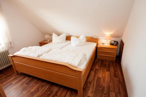 1 dormitorio con 1 cama con sábanas y almohadas blancas en 50155 Haus Mundhenk, en Carolinensiel