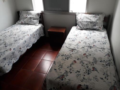 1 dormitorio pequeño con 2 camas y mesa en Condomínio Praia de Marrakesch, en Guarujá