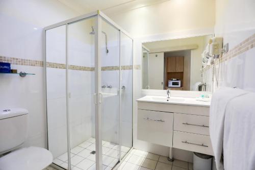 a white bathroom with a shower and a sink at Parkhaven in Nowra
