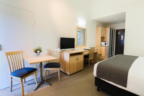 a hotel room with a bed and a desk with a computer at Parkhaven in Nowra
